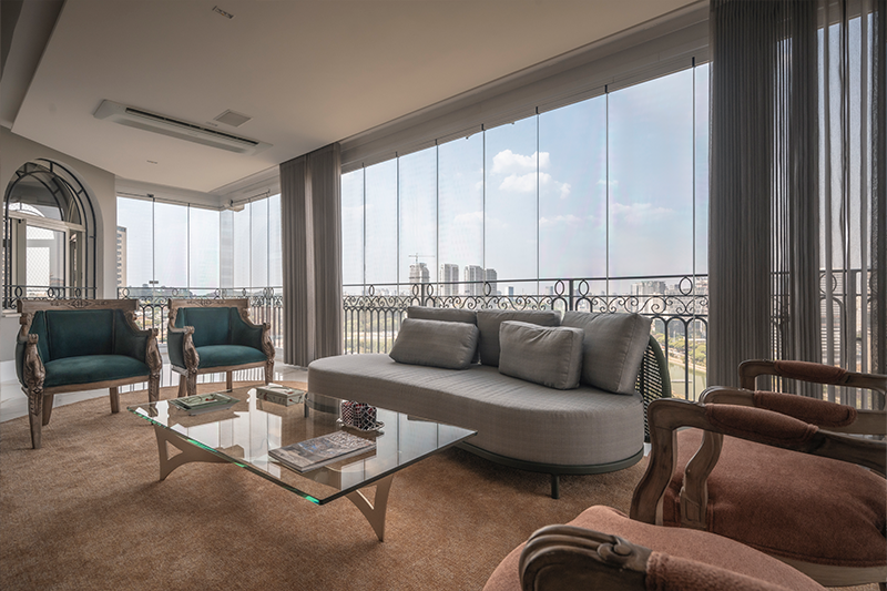 Envidraçamento automatizado integra a varanda ao living, amplia o espaço e garante conforto acústico sem abrir mão da vista.