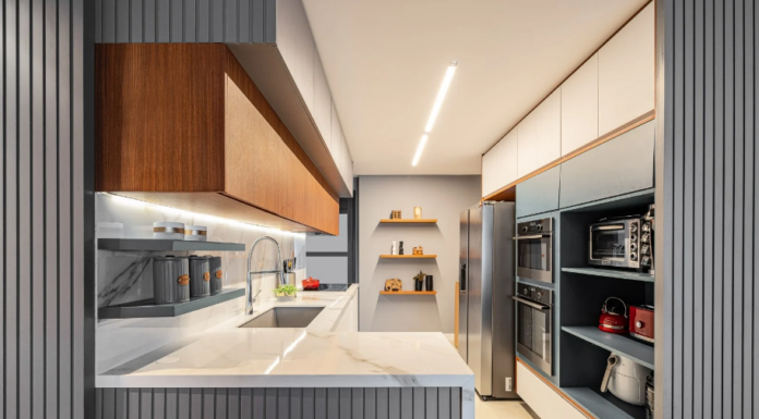 Regra do triângulo da cozinha: saiba como deixar o seu espaço mais prático Cozinha corredor com triângulo eficiente: pia de um lado, geladeira do outro – Foto: Flávio Dias | Projeto: Vanessa Vidal Arquitetura