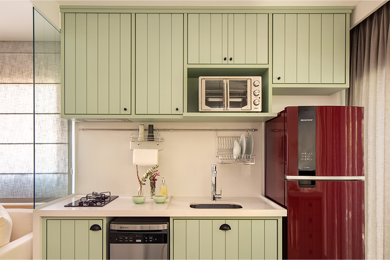 Projeto: Juliana Fabrizzi | O vermelho da geladeira quebra a leveza do verde criando uma harmonia ousada