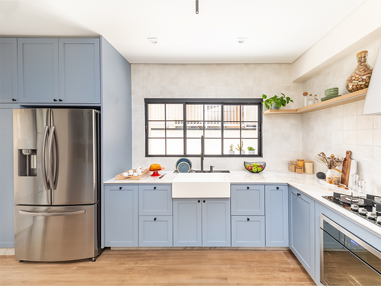 Com a marcenaria azul e a cuba no estilo farm sink, a cozinha também foi completamente repaginada pelo arquiteto Bruno Moraes a partir de referências retrô modernas