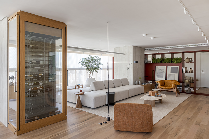 Batizado de 'Apartamento Ripas', o projeto exibe uma área de estar grandiosa que reflete a identidade dos moradores. Uma adega entrega imponência logo na entrada e possui duas portas que servem ao estar e à sala de jantar 