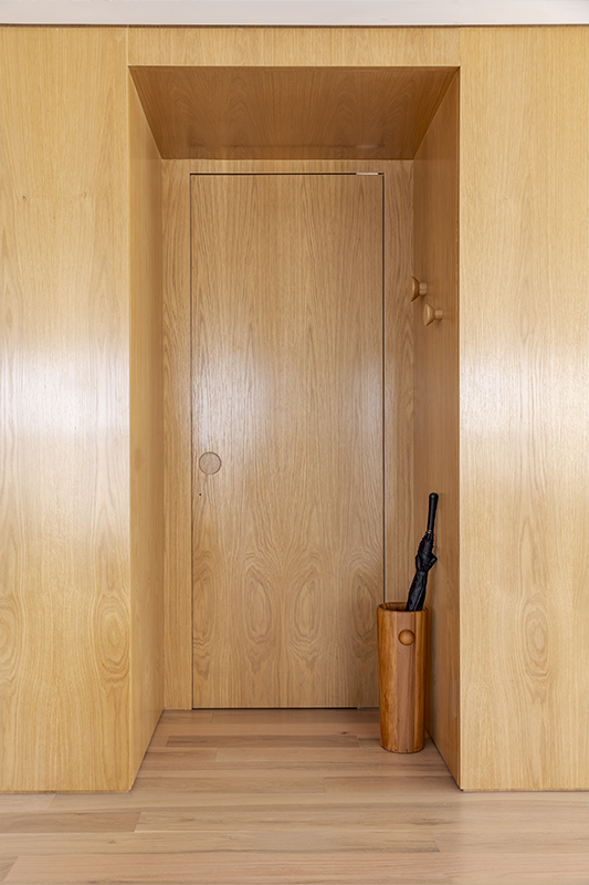 Discreto, o lavabo se esconde no painel de madeira