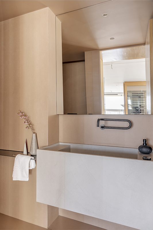 Discreto, o lavabo se esconde no painel de madeira