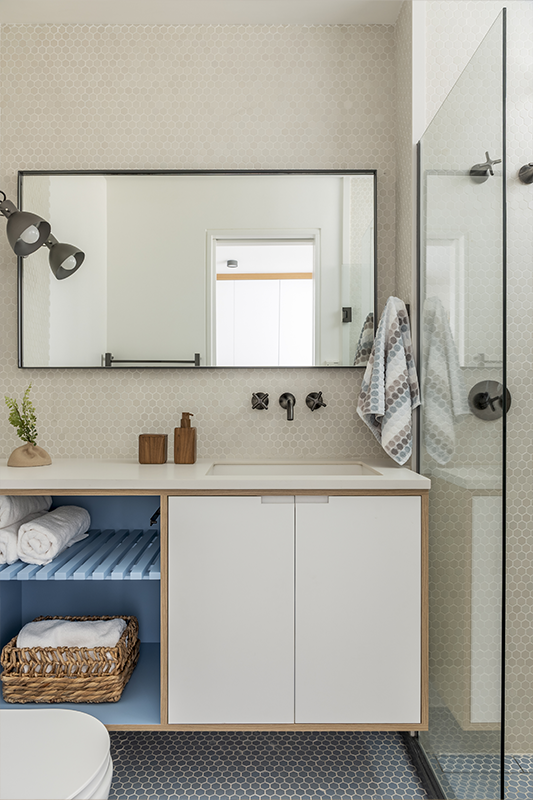 Nos banheiros, os revestimentos hexagonais feitos à mão pela Keramika refletem as cores escolhidas pelas crianças. No dele, pastilhas artesanais azuis e metais em grafite escovado. No dela, pastilhas e cuba de concreto pigmentado em tom rosado 