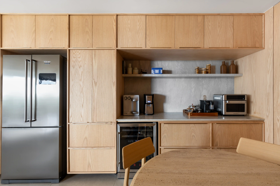 O acabamento amadeirado nos armários transforma a cozinha em ponto de destaque – Produção: Luciana Cardoso | Fotos: Júlia Tótoli/Divulgação | Projeto: Bloco Arquitetos