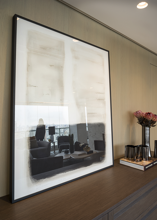 Nem sempre a obra de arte precisa ser pendurada na parede. Neste projeto, o quadro ficou apoiado no aparador, uma maneira delicada que evita intervenções na parede