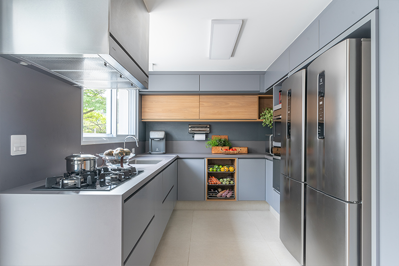 Na bancada revestida com lâmina sinterizada, a arquiteta Isabella Nalon elegeu uma cuba generosa e alinhada com o tamanho da cozinha