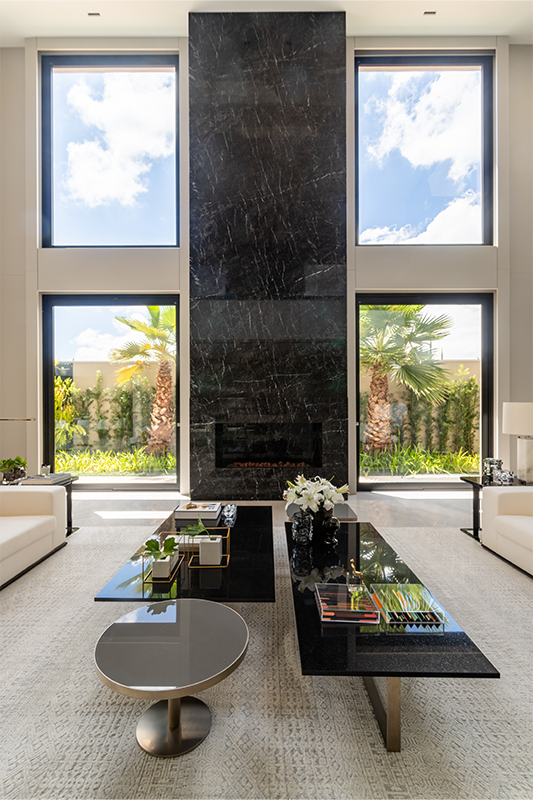 No projeto dessa residência assinada pela arquiteta Patricia Penna, o mármore natural foi eleito para revestir toda a parte da lareira do suntuoso living com pé-direito duplo 