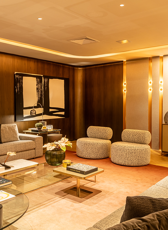 Para entregar uma atmosfera imersiva, a arquiteta investiu em diversos recursos dentro do projeto luminotécnico do seu ambiente na mostra Artefacto 2026. A iluminação indireta se fez presente nas fitas de LED embutidas nas sancas e no formato circular do forro, além das paredes