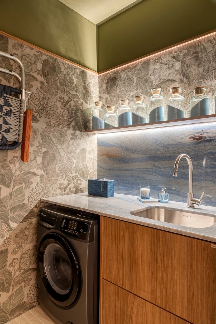 Cozinha e lavanderia integradas reforçam a praticidade do cotidiano sem abrir mão da estética.