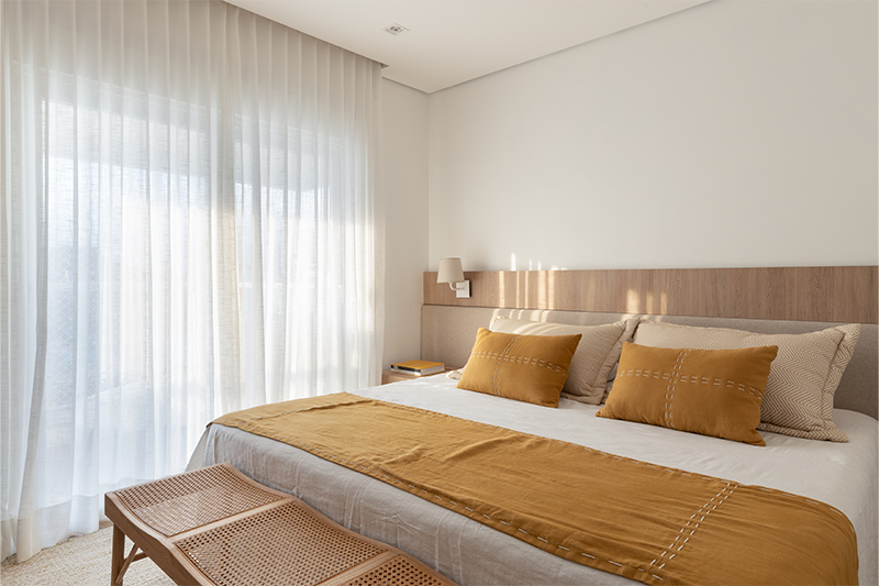 Na área íntima, conforto e continuidade material criam uma atmosfera de descanso.