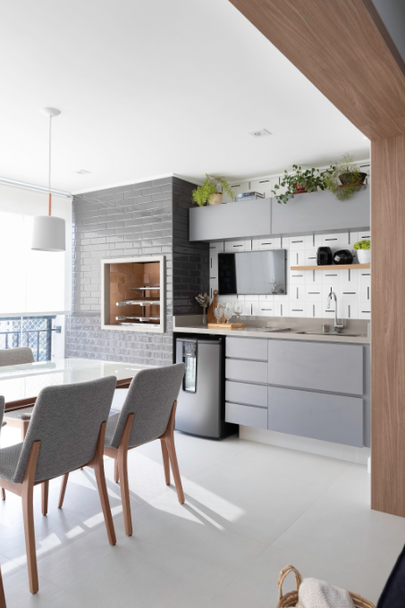 Uma pia próxima à churrasqueira elimina deslocamentos e concentra o preparo no próprio espaço – Foto: Monica Assan | Projeto: Due Arquitetos 