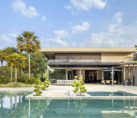 Sofisticação em meio ao verde: paisagismo valoriza a arquitetura e promove bem-estar Área de lazer com duas piscinas — a principal, mais ampla, e uma segunda em estilo spa